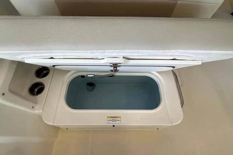 Slide: The Image of 2026 Boston Whaler 210 Vantage livewell with open lid, showcasing interior features. - 11