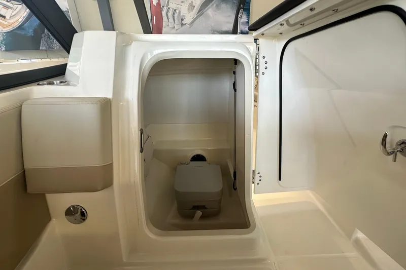 Slide: The Image of 2026 Boston Whaler 210 Vantage interior with compact marine toilet. - 17