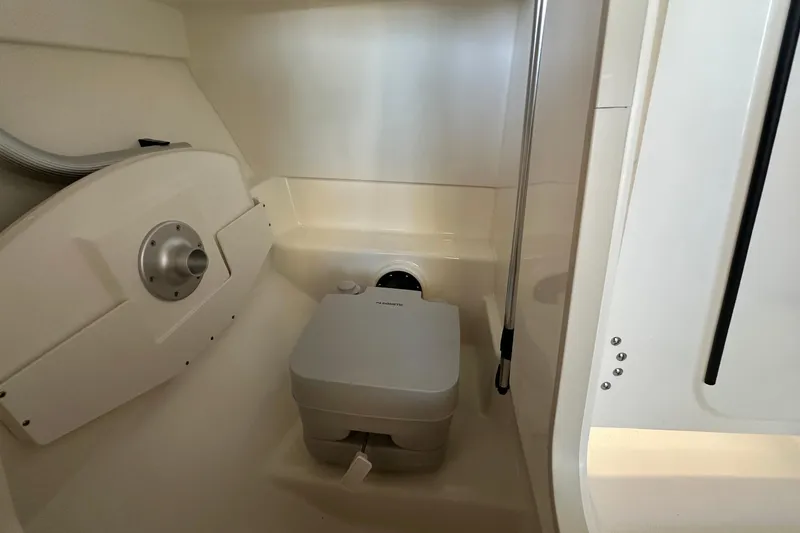 Slide: The Image of 2026 Boston Whaler 210 Vantage interior with compact marine toilet. - 18