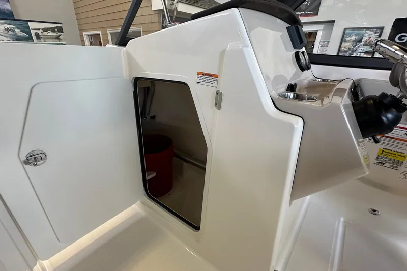 Slide: The Image of 2026 Boston Whaler 210 Vantage boat console with open storage compartment. - 22