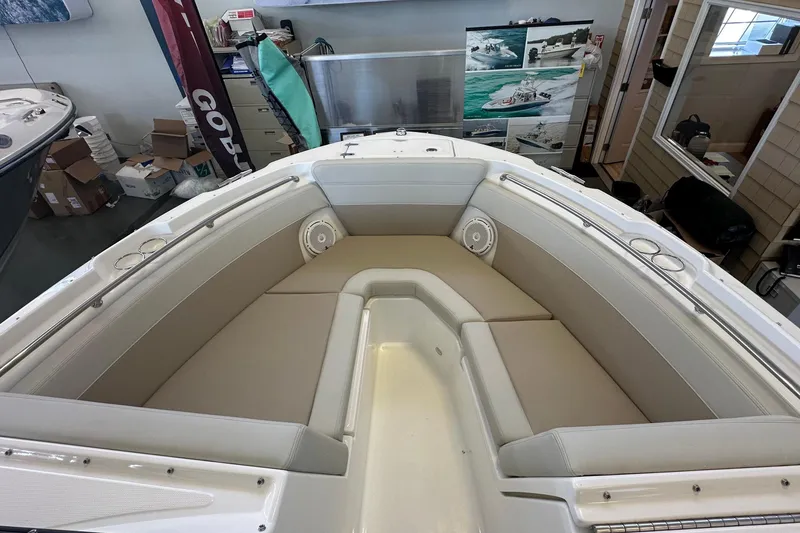 Slide: The Image of 2026 Boston Whaler 210 Vantage boat interior with cushioned seating and cup holders. - 25