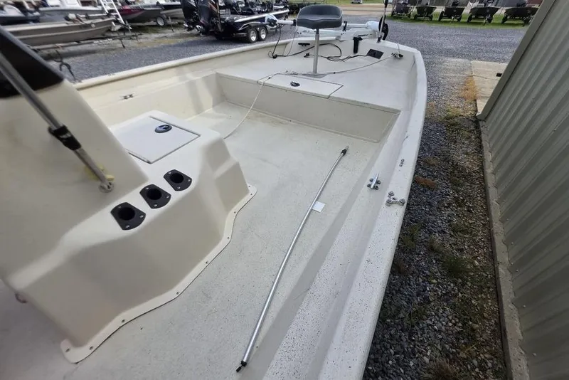 Slide: The Image of 2012 Xpress HD22CCF boat interior with seating and storage, parked outdoors. - 10