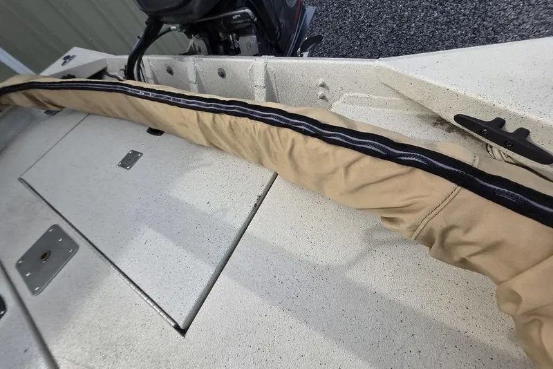 Slide: The Image of 2012 Xpress HD22CCF boat deck with beige cover and motor in background. - 14