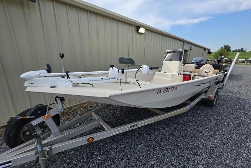 Slide: The Image of 2012 Xpress HD22CCF boat on trailer, parked beside a metal building. - 2