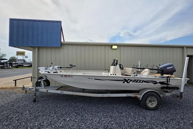 Slide: The Image of 2012 Xpress HD22CCF boat on trailer, parked beside a building. - 3
