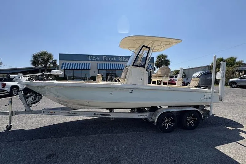The Image of 2022 Scout 231 XSB boat on trailer at dealership, sunny day. - 1