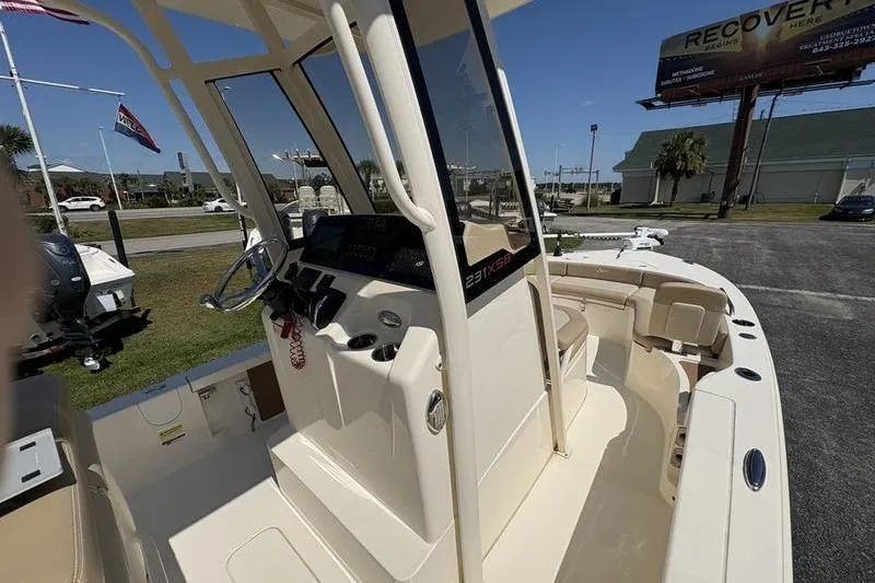 Slide: The Image of 2022 Scout 231 XSB boat interior with steering console and seating area. - 11