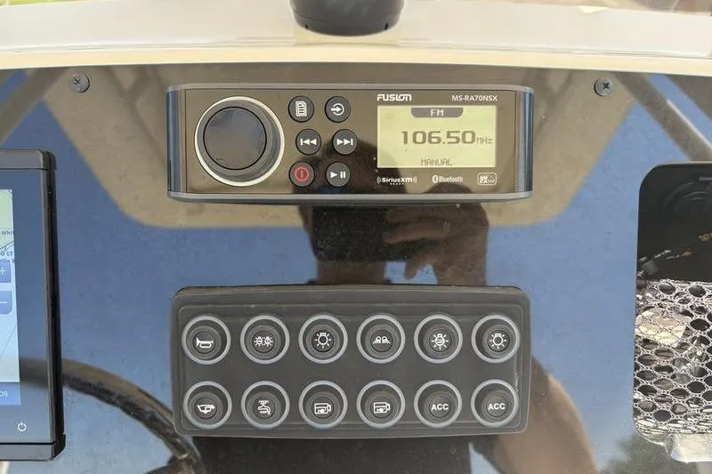 Slide: The Image of Control panel of 2022 Scout 231 XSB boat with Fusion radio and button interface. - 15