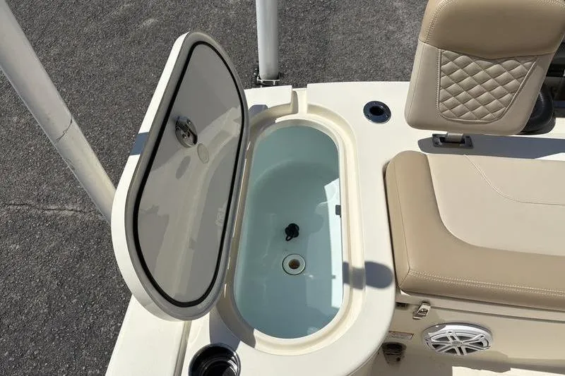 Slide: The Image of 2022 Scout 231 XSB boat with open storage compartment and cushioned seating. - 20