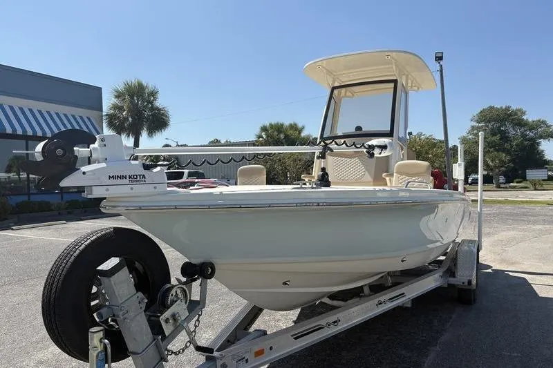 Slide: The Image of 2022 Scout 231 XSB boat on trailer with Minn Kota trolling motor, parked outdoors. - 25
