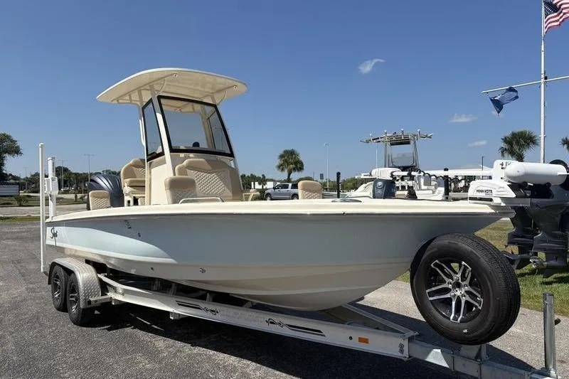 Slide: The Image of 2022 Scout 231 XSB boat on trailer, parked outdoors under clear sky. - 27