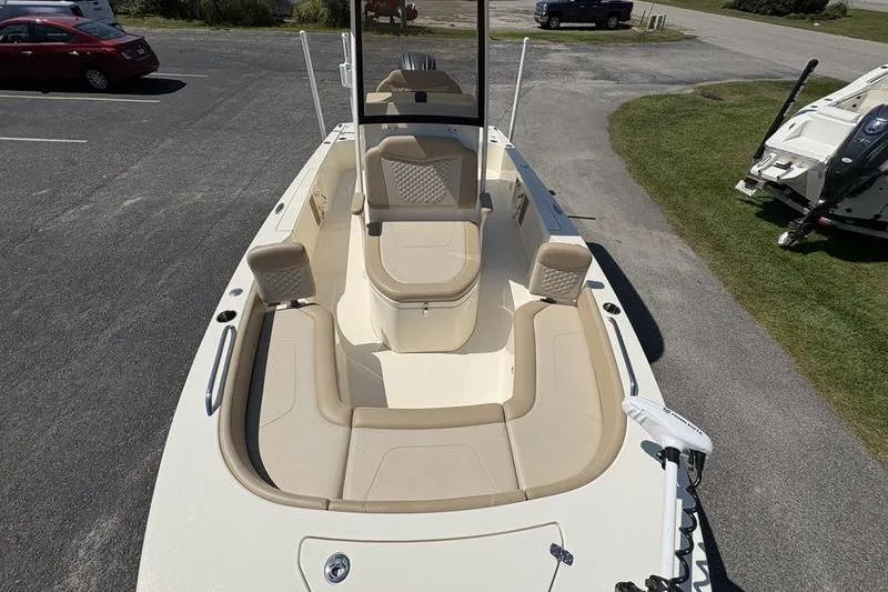Slide: The Image of 2022 Scout 231 XSB boat with beige seating, parked on pavement. - 3