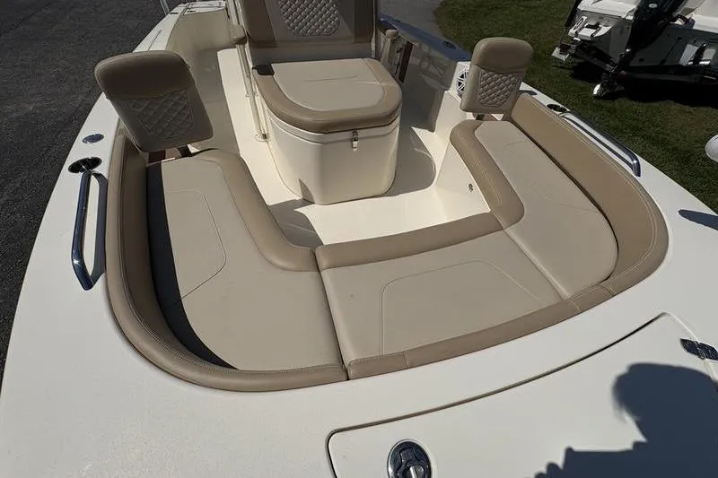 Slide: The Image of 2022 Scout 231 XSB boat interior with beige cushioned seating and storage. - 4