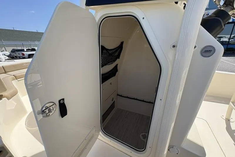 Slide: The Image of 2022 Scout 231 XSB boat interior cabin with open door, showcasing storage space. - 9
