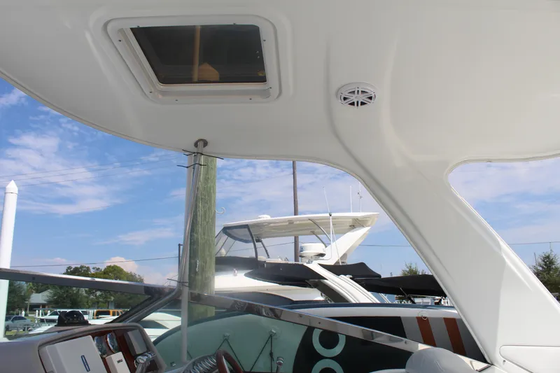 Slide: The Image of 2004 Formula 40 Performance Cruiser interior with sunroof and speaker, docked under clear sky. - 14