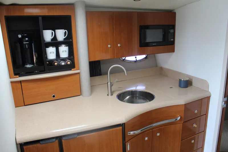Slide: The Image of 2004 Formula 40 Performance Cruiser kitchen with wood cabinets, sink, microwave, and coffee maker. - 24