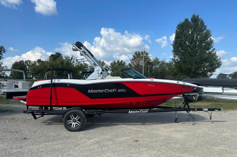 The Image of 2019 MasterCraft NXT20 boat in vibrant red on a trailer, parked outdoors. - 1