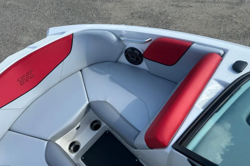 Slide: The Image of 2019 MasterCraft NXT20 boat interior with red and white seating, cup holders, and speaker. - 16