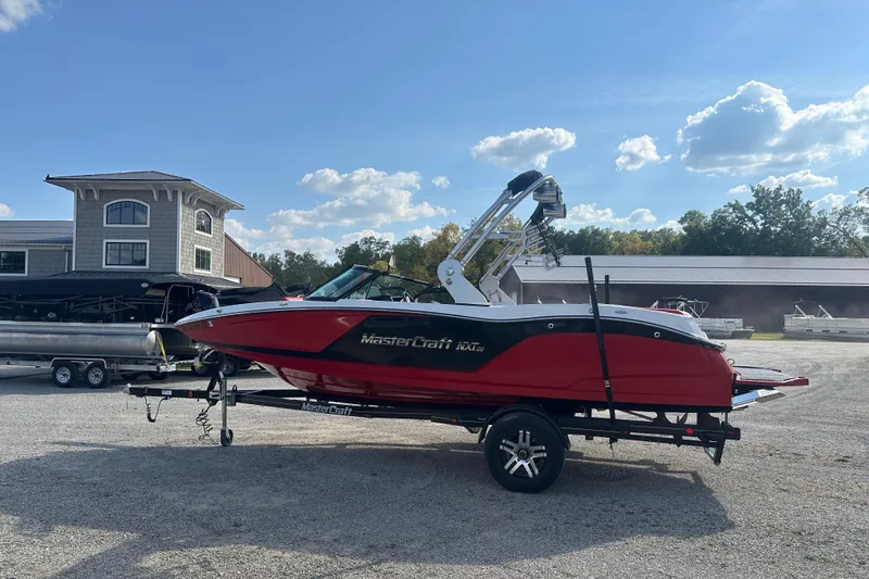 Slide: The Image of 2019 MasterCraft NXT20 boat on trailer, red and black design, parked outdoors. - 3
