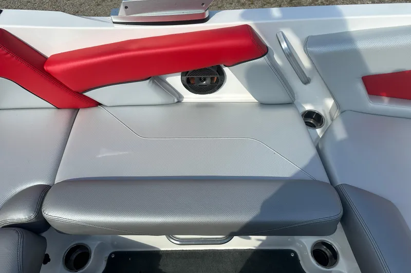 Slide: The Image of 2019 MasterCraft NXT20 boat interior with red and gray seating, cup holders, and speaker. - 9