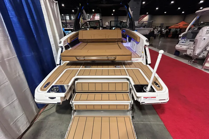 Slide: The Image of 2026 Chaparral SSX 6 boat interior with tan seating and deck, showcased indoors. - 2