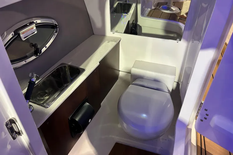 Slide: The Image of 2026 Chaparral SSX 6 boat bathroom with sink, toilet, and porthole window. - 6