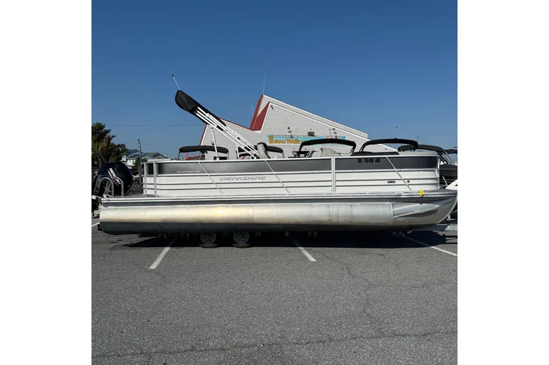 The Image of 2025 Berkshire 24CL 2.75 LE pontoon boat parked outdoors under clear blue sky. - 1