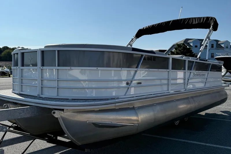Slide: The Image of 2025 Berkshire 24CL 2.75 LE pontoon boat on trailer, parked outdoors. - 4