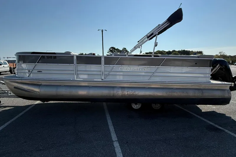 Slide: The Image of 2025 Berkshire 24CL 2.75 LE pontoon boat parked in a lot, side view. - 5