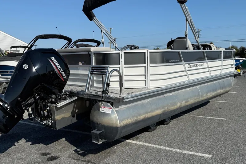 Slide: The Image of 2025 Berkshire 24CL 2.75 LE pontoon boat with Mercury outboard engine in parking lot. - 8