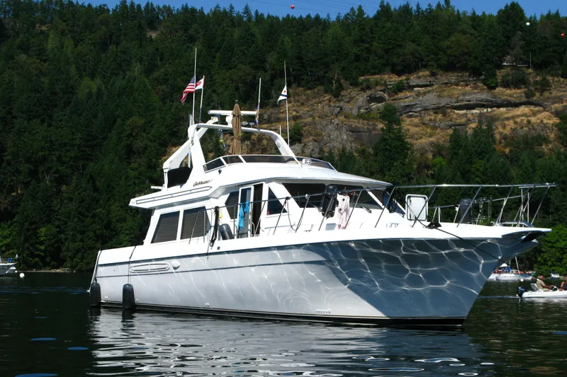 Slide: The Image of Luxury Navigator 53 yacht from 2000 on serene water, surrounded by lush forest. - 1