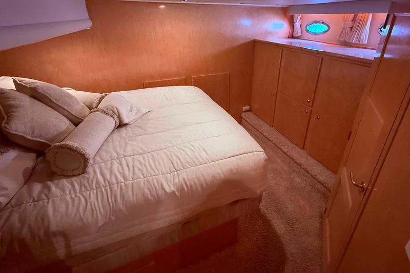 Slide: The Image of Luxurious bedroom interior of a 2000 Navigator 53 yacht with cozy bedding and wood paneling. - 12