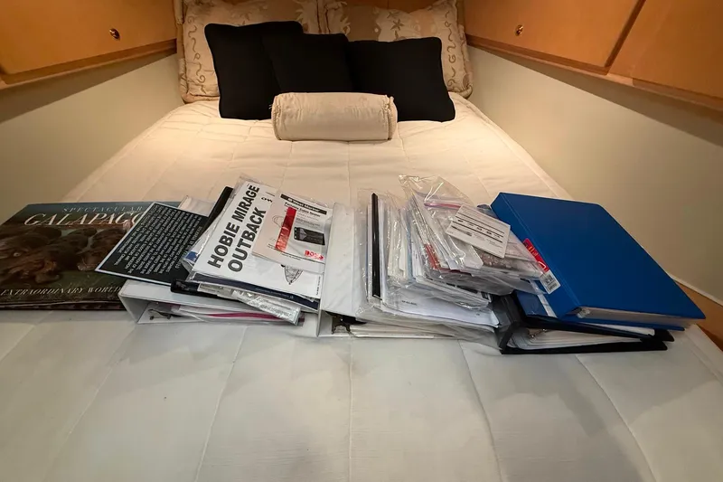 Slide: The Image of Documents and binders on a bed inside a 2000 Navigator 53 yacht cabin. - 15