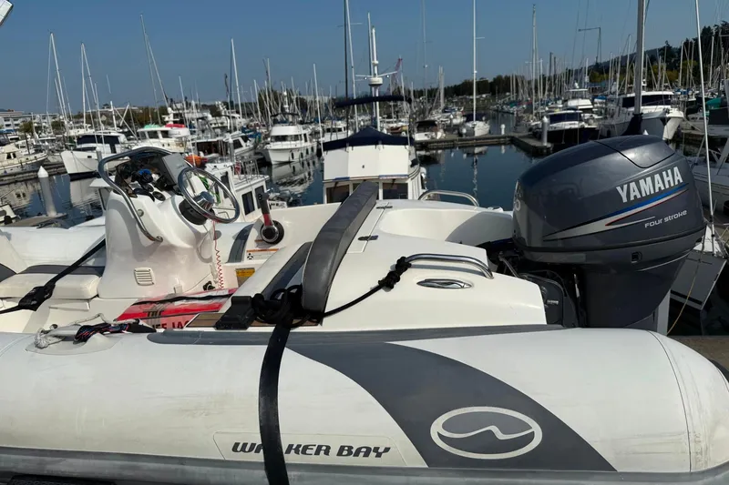 Slide: The Image of Inflatable boat with Yamaha engine docked at marina, surrounded by sailboats. - 17