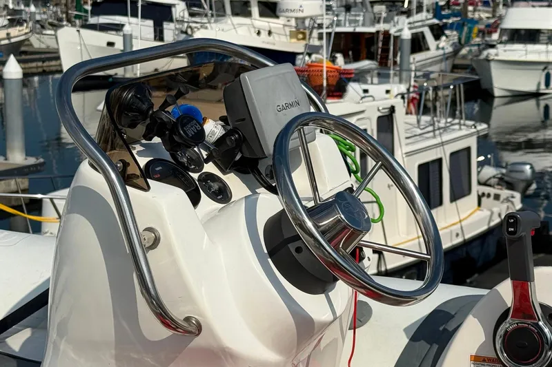 Slide: The Image of Steering wheel and controls of a 2000 Navigator 53 yacht at a marina. - 19