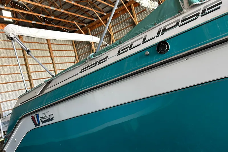 Slide: The Image of 1991 Wellcraft 232 Eclipse boat in storage, showcasing teal and white exterior. - 14