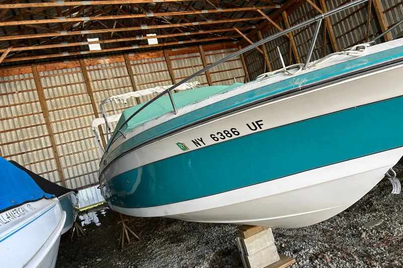 Slide: The Image of 1991 Wellcraft 232 Eclipse boat stored indoors, teal and white exterior. - 15