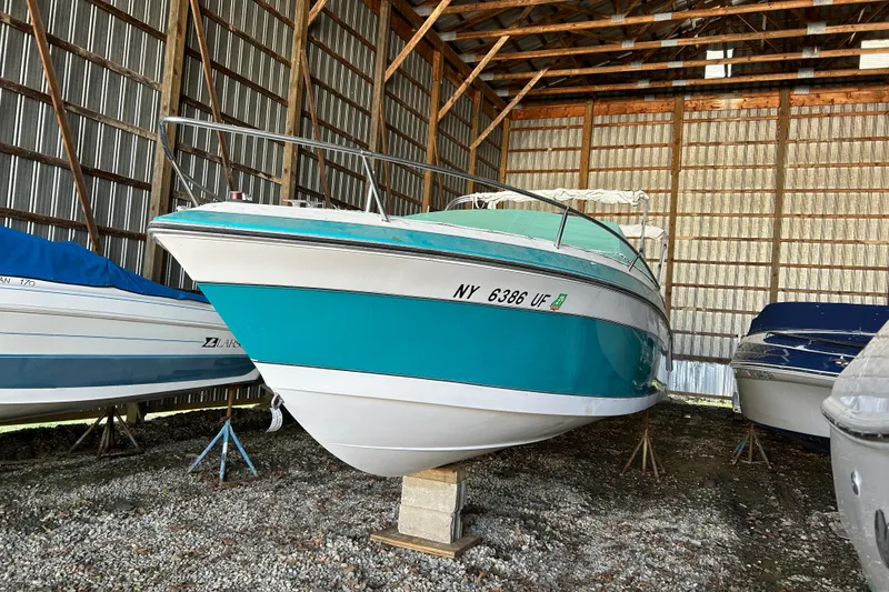 Slide: The Image of 1991 Wellcraft 232 Eclipse boat stored in a metal shed. - 16
