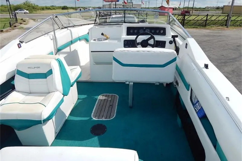 Slide: The Image of 1991 Wellcraft Eclipse 232 boat interior with teal and white seating, steering wheel, and dashboard. - 2