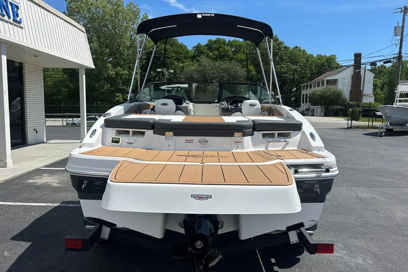 Slide: The Image of 2026 Chaparral 21 SSi boat with tan deck, parked outdoors near a building. - 4