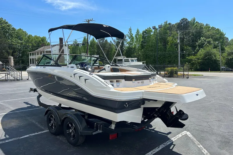 Slide: The Image of 2026 Chaparral 21 SSi boat on trailer, parked outdoors under clear blue sky. - 7