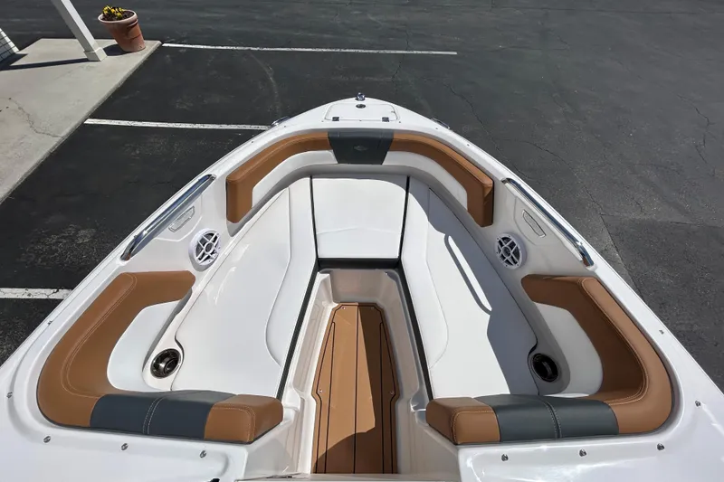 Slide: The Image of 2026 Chaparral 21 SSi boat interior with tan and white seating, docked in a parking area. - 9