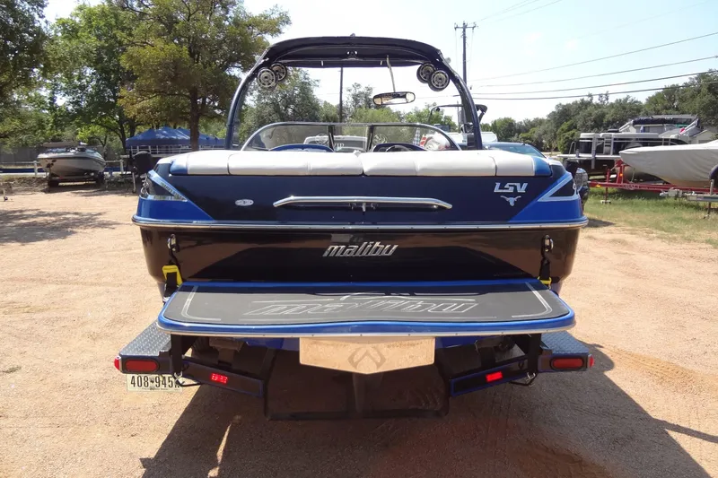 Slide: The Image of 2007 Malibu Wakesetter 23 LSV boat, rear view, parked on sandy ground. - 3