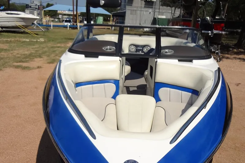 Slide: The Image of 2007 Malibu Wakesetter 23 LSV boat with blue and white interior, parked outdoors. - 7