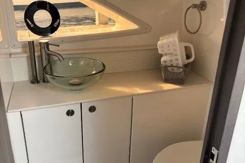 Slide: The Image of 2024 Sea Ray Sundancer 320 bathroom with modern glass sink and sleek cabinetry. - 11