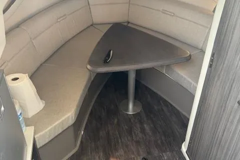Slide: The Image of 2024 Sea Ray Sundancer 320 interior with cushioned seating and triangular table. - 14