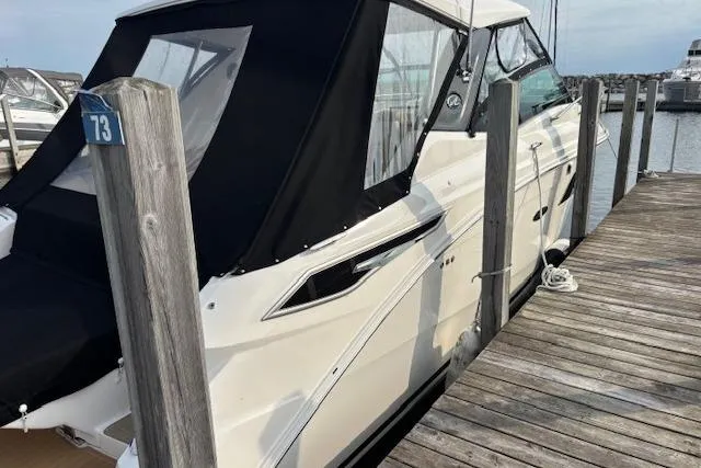 Slide: The Image of 2024 Sea Ray Sundancer 320 docked, featuring sleek design and black canopy. - 4