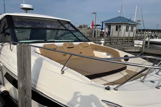 Slide: The Image of 2024 Sea Ray Sundancer 320 yacht docked at marina with luxurious seating. - 5