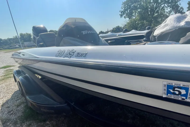 Slide: The Image of 2012 Triton 21 XS Elite boat on trailer, sunny outdoor setting. - 3