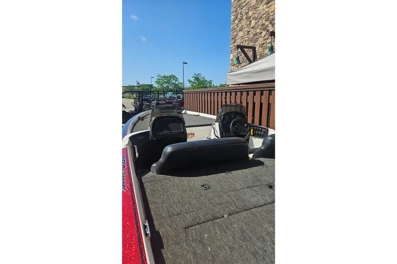 Slide: The Image of 1997 Nitro 884 Savage boat interior with steering wheel and seating, parked outdoors. - 3